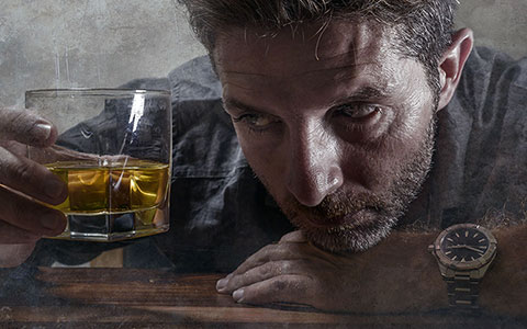 Father staring at glass of whiskey