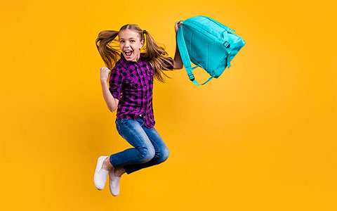 Happy girl jumping with backpack