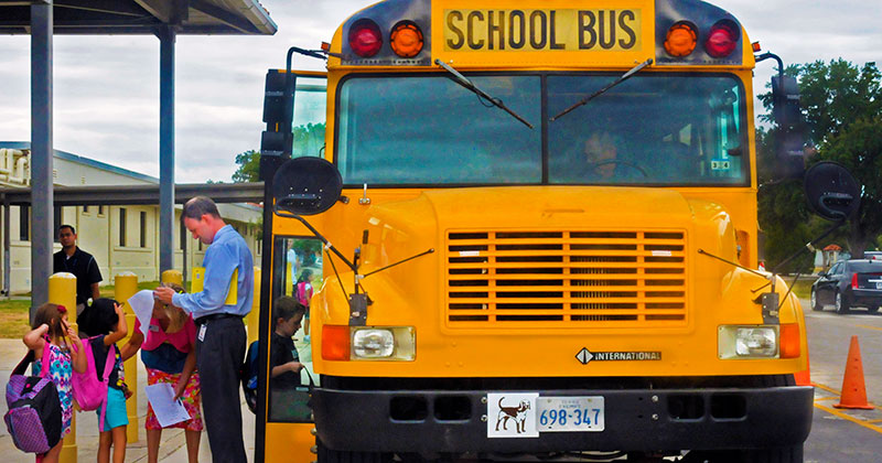 Young child boarding a yellow school bus