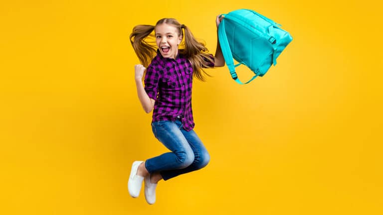 Happy girl jumping with marine backpack