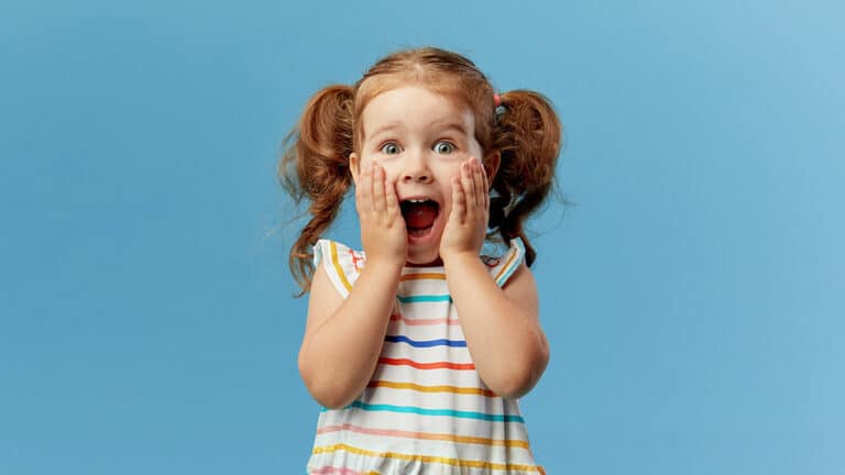 Toddler girl smiling with surprise